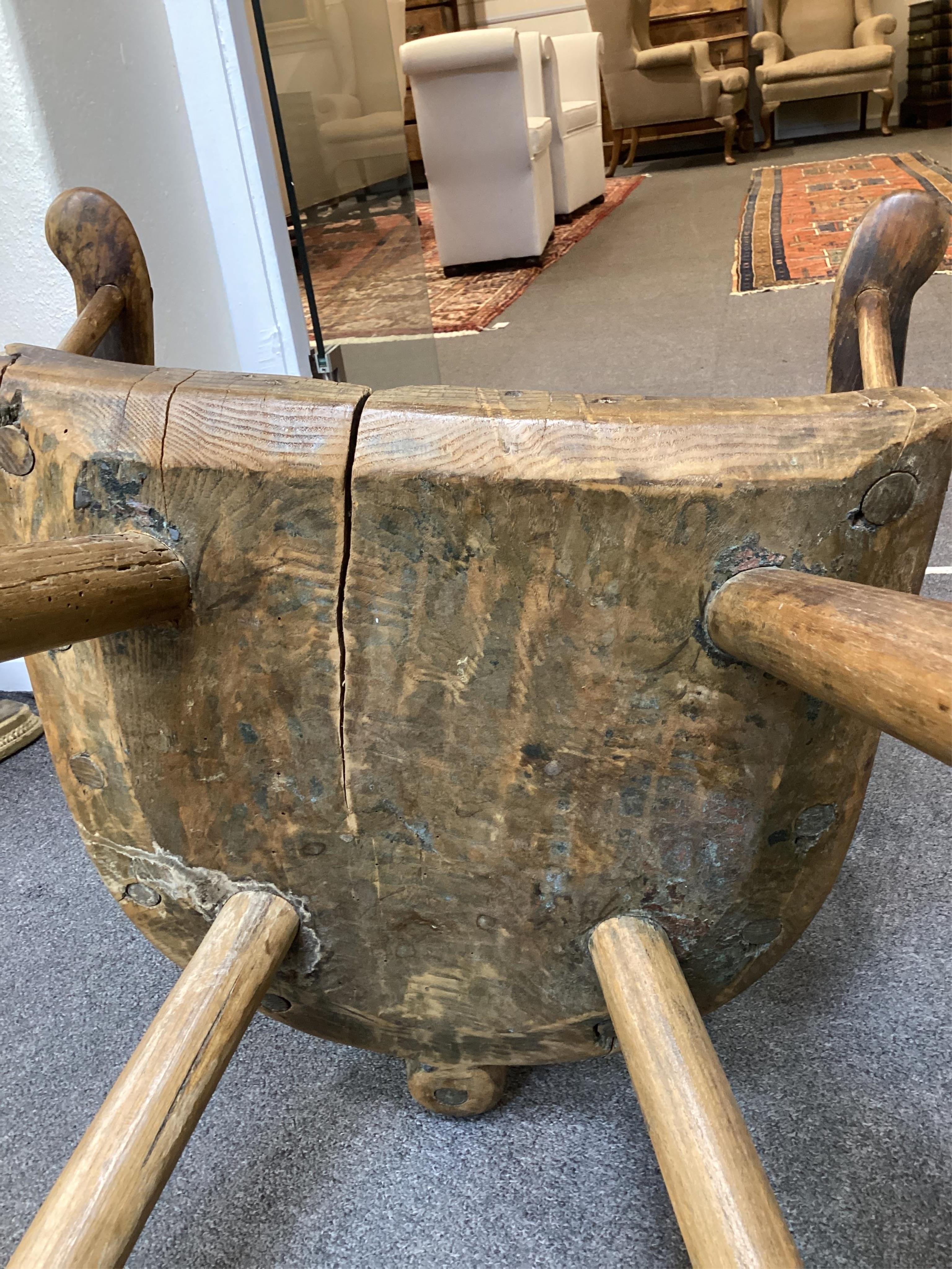 An 18th or 19th century primitive ash and elm Windsor armchair